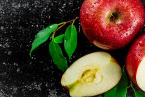 moitié et entier pommes avec feuilles sur le tableau. photo