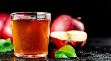 une plein verre de Pomme jus avec feuilles. photo