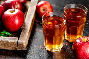 une verre de Pomme jus sur le tableau. photo