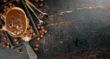 Noisette beurre dans une assiette sur une Coupe planche avec papier. photo