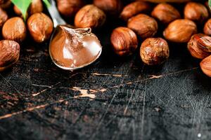 Noisette beurre dans une cuillère sur le tableau. photo