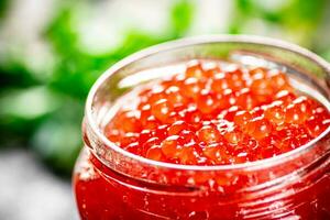 un ouvert pot de rouge caviar avec légumes verts. photo