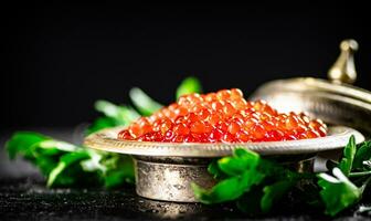 plein bol de rouge caviar sur le tableau. photo