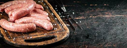 brut saucisses sur une Coupe planche. photo