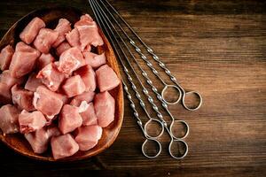 pièces de brut porc kebab sur une assiette avec brochettes. photo