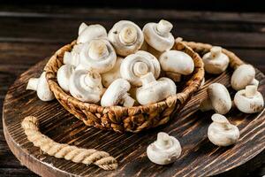 Frais champignons dans une panier sur une en bois plateau. photo