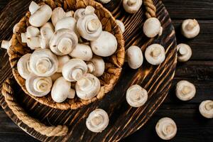 Frais champignons dans une panier sur une en bois plateau. photo