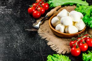 mozzarella dans une assiette sur une serviette de table avec tomates et salade. photo