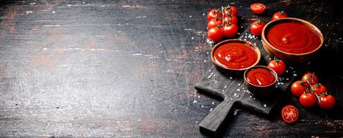 tomate sauce sur une en bois Coupe planche avec pièces de sel. photo