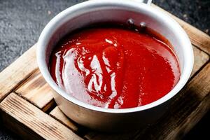 tomate sauce sur une en bois plateau. photo