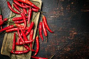 rouge le Chili poivre dosettes sur une Coupe planche. photo