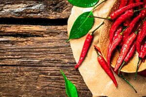 chaud le Chili poivrons avec feuilles sur une plaque. photo