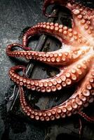 tentacules de une Frais poulpe sur une Coupe planche. photo