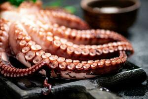 tentacules de une Frais poulpe sur une Coupe planche. photo