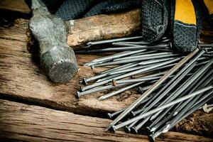 marteau avec ongles et gants sur le tableau. photo