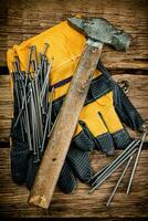 marteau avec ongles et gants sur le tableau. photo