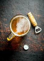 Bière dans une verre tasse et ouvreur. photo