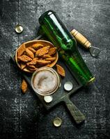 Bière et les miettes sur une noir Coupe planche. photo