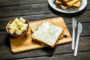 grillé pain et beurre sur le planche. photo