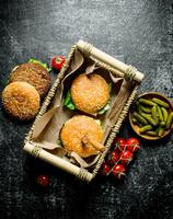 des hamburgers dans le panier et cornichons dans le bol. photo