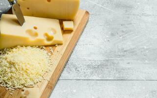 Frais râpé fromage sur une en bois planche. photo