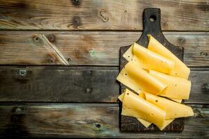 mince tranches de fromage sur le Coupe planche. photo