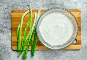 acide crème dans bol avec vert oignons. photo