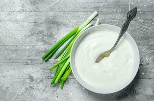 acide crème avec vert oignons dans bol . photo