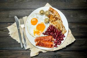 traditionnel Anglais petit déjeuner avec frit œufs, saucisses et haricots. photo