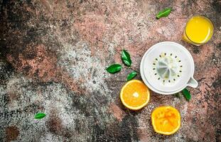 Orange jus dans une verre et une presse-agrumes. photo