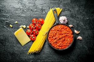 bolognaise sauce dans la poêle avec sec Pâtes, herbes et Parmesan. photo