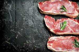 brut du boeuf steaks avec parfumé Romarin. photo