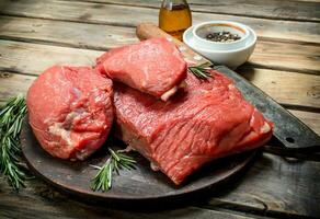 brut Viande. Frais du boeuf sur une Coupe planche avec herbes et épices. photo