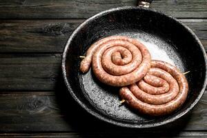 brut saucisse dans une poêle. photo