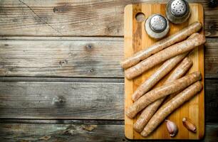 brut saucisses avec Ail et assaisonnements sur le planche. photo