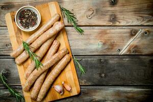 brut saucisses avec Ail et assaisonnements sur le planche. photo