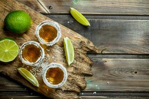 Tequila dans une coup verre de sel sur le Coupe planche. photo