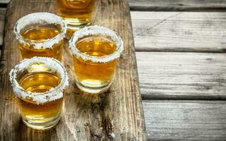 Tequila dans une coup verre sur une Coupe planche avec tranches de chaux. photo