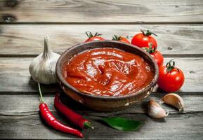 tomate sauce dans bol avec rouge chaud poivre. photo