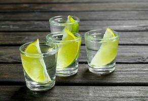 Vodka avec citron vert tranches dans une coup verre. photo