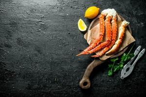 Crabe sur une Coupe planche avec citron et persil. photo