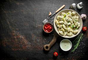 Dumplings avec épices, ail, acide crème et tomate pâte. photo