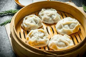 Frais Dumplings de manta avec Viande dans une bambou bateau à vapeur. photo