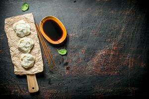 Dumplings manta sur une Coupe planche avec soja sauce. photo