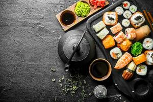 traditionnel Japonais Sushi et Rouleaux avec vert thé dans le théière. photo