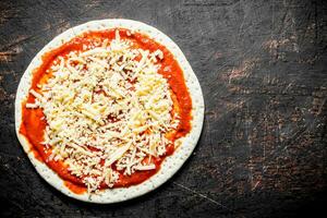 préparation Pizza. roulé en dehors rond pâte avec tomate pâte et fromage. photo