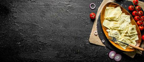 Ravioli avec tomates, sauce et oignon anneaux. photo