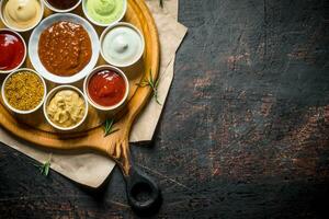 gros ensemble de sauces sur une Coupe planche avec papier. photo