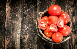 Frais tomates dans une en bois seau. photo