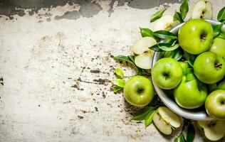 Frais vert pommes dans une plat sur rustique Contexte. photo